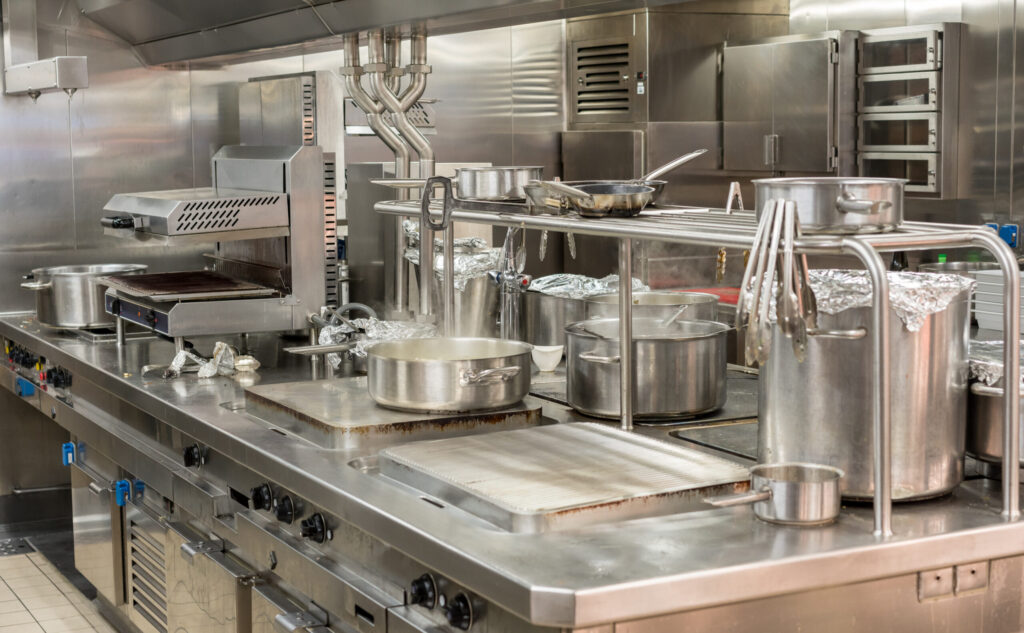 Food being cooked in commercial stainless steel kitchen in restaurant